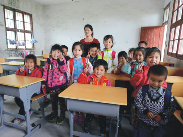 公司為一山村小學(xué)捐贈(zèng)一批課桌椅，孩子們高興地和老師一起合影